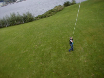 Look, it's some guy holding a kite string, who's holding the camera up there?